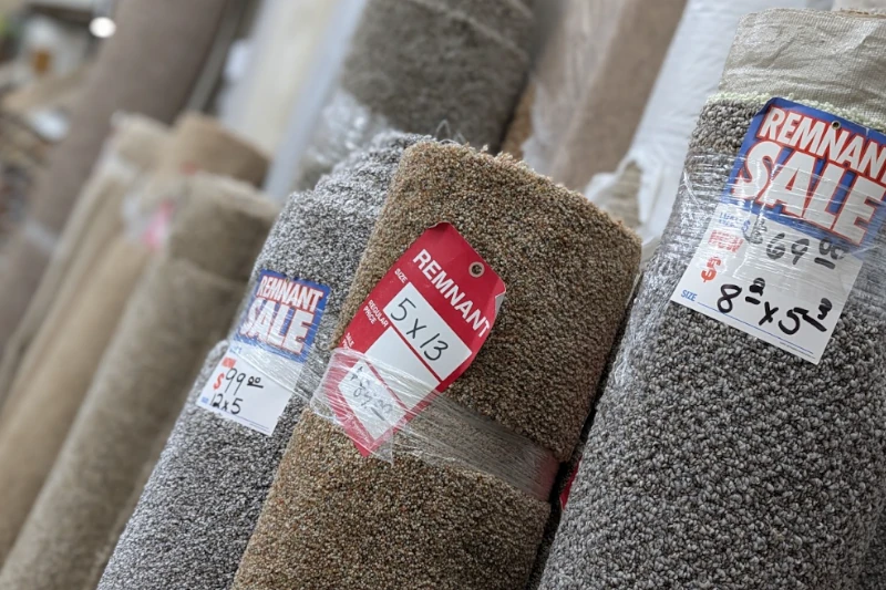 Carpet sales consultation in a flooring showroom, with a salesperson showing carpet samples and explaining options to customers.