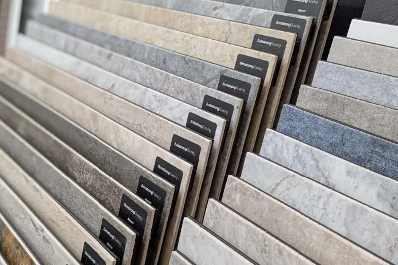 Tile Store Tile Store showroom featuring a customer browsing a wide selection of tile samples in various colors, patterns, and finishes.